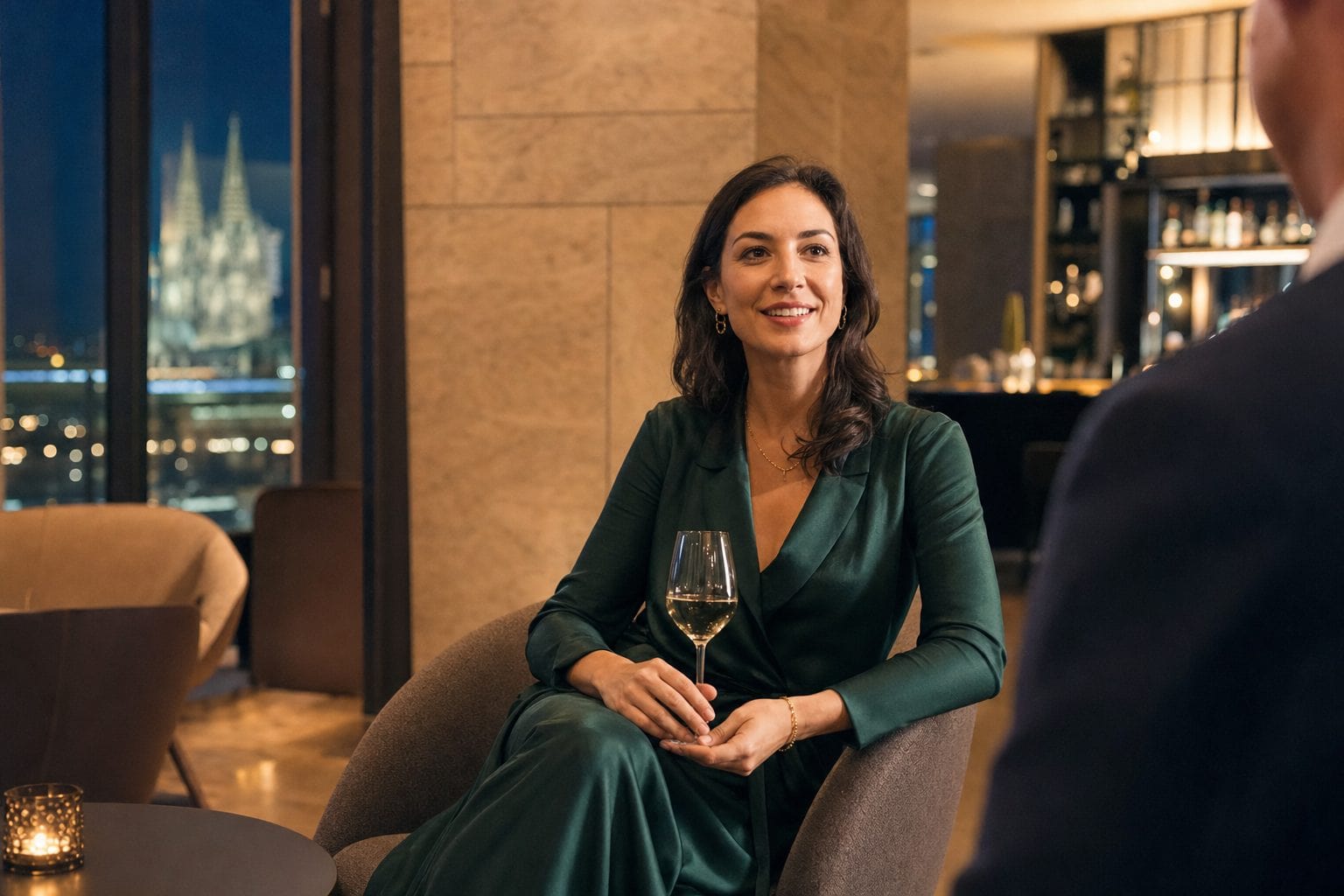 Elegant gekleidete Frau im Gespräch in einer Kölner Hotel-Lounge am Abend