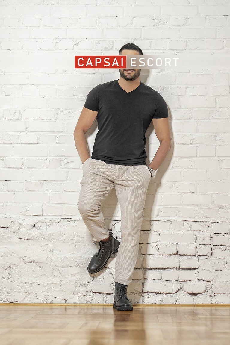 Callboy Carlos in lässigen Outfit an der Wand gelehnt.