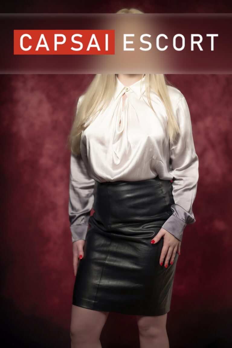 Escort Dame Estella in einer weißen Bluse mit schwarzem Rock.