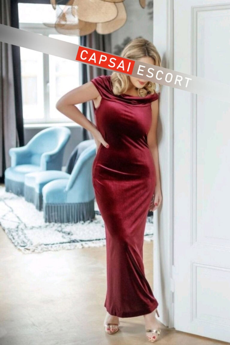 Escort Dame Freya in einem roten langen Kleid und High Heels.
