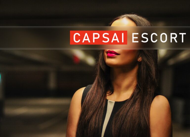 Escort Dame Isabelle in einem schwarzen Kleid und pinken Lippen in einer Nahaufnahme.