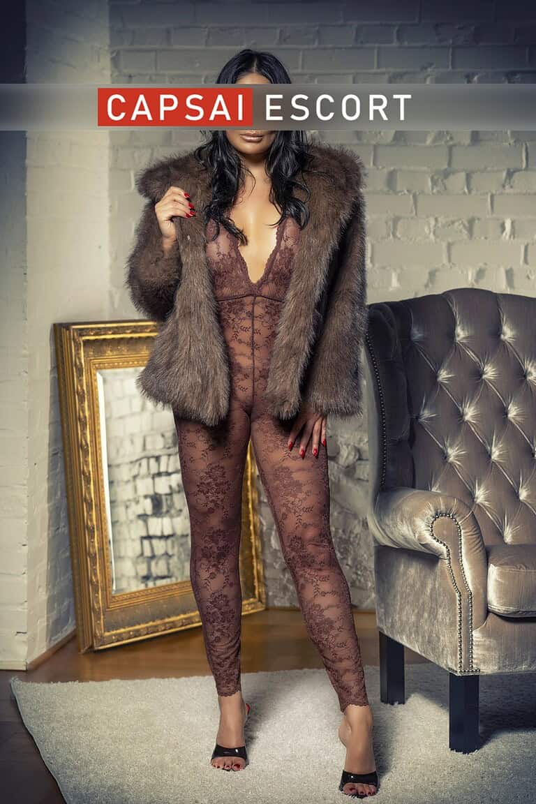 Escort Dame Kim in einem transparentem Body und einer Felljacke.