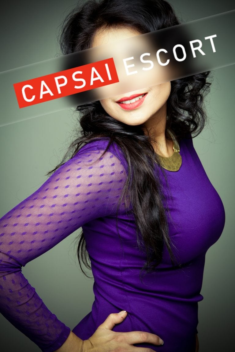 Escort Dame Luana in einem blauen Kleid.