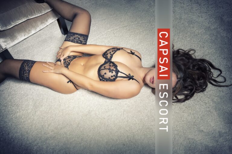 Escort Dame Lucia in schwarzen transparenten Dessous und schwarzen Nylons auf dem Boden breitbeinig liegend,