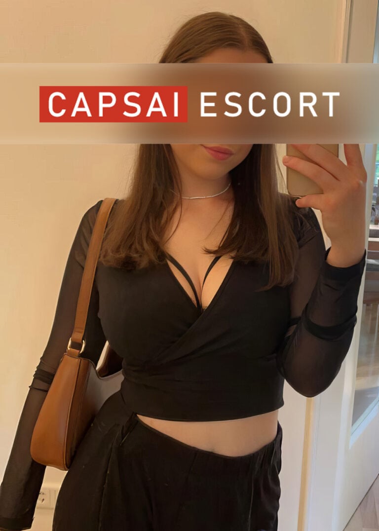 Escort Dame Noemi in einem schwarzem Oberteil.